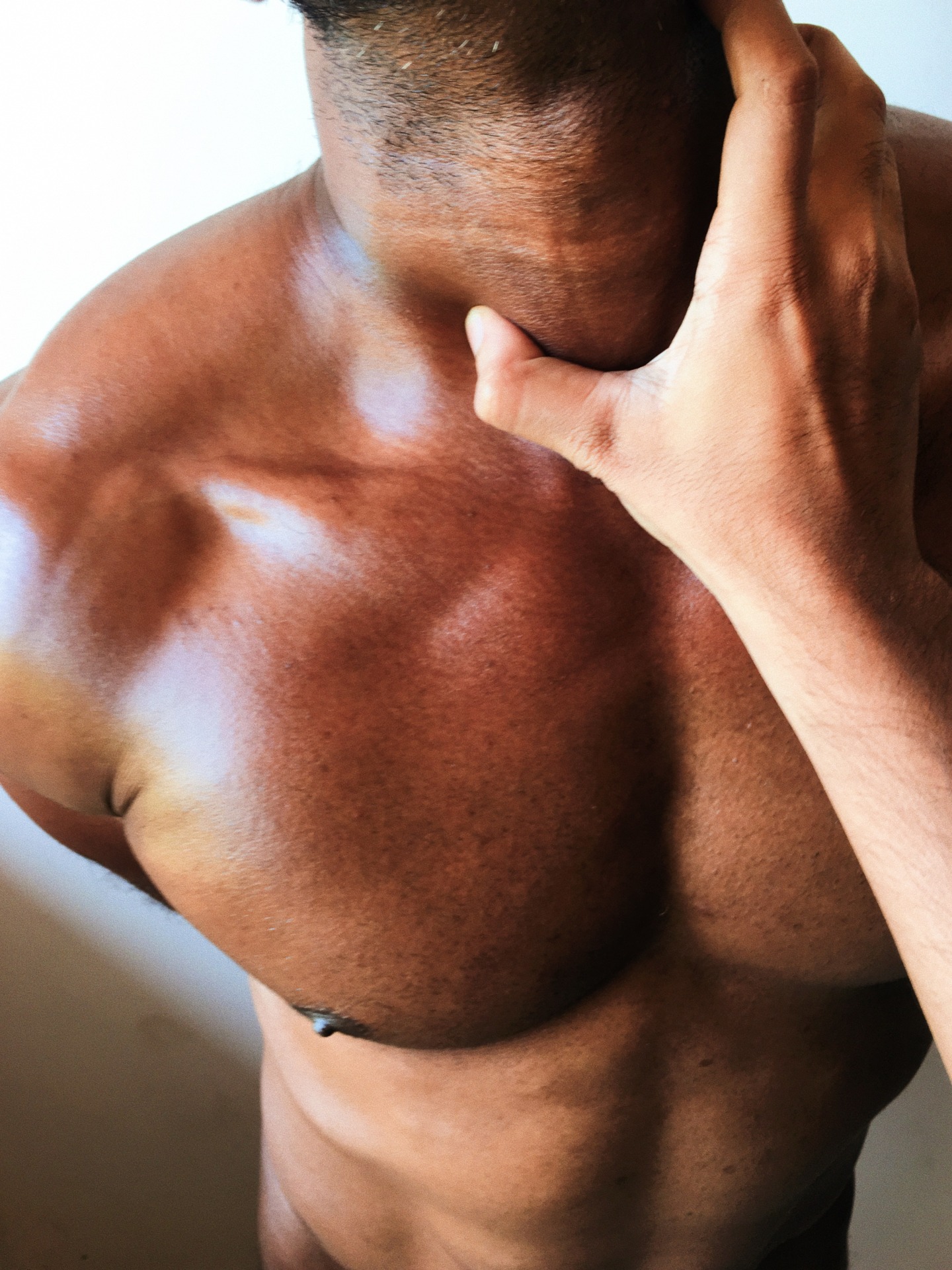 Model posing in a photoshoot with an arm around his neck.