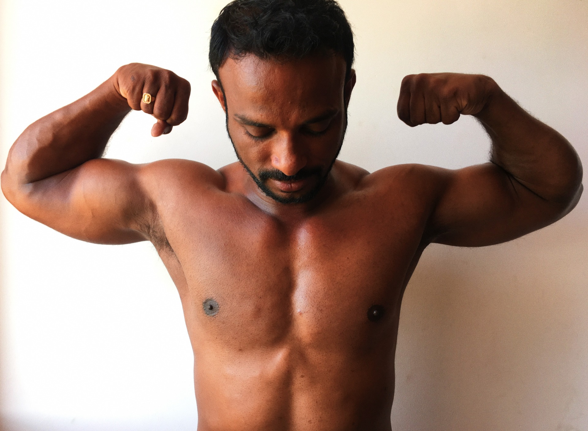 Indian pornstar Charan flexing his muscles.